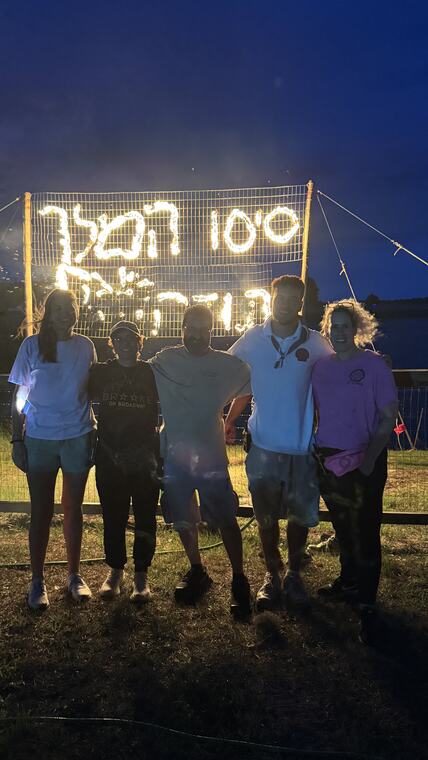 צללית קבוצה מול שלט מואר